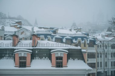 Çatıları olan şehrin üzerinde şiddetli kar yağışı