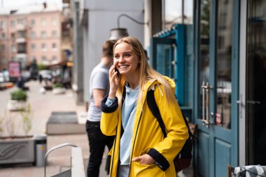 Sokakta yürüyen ve akıllı telefon kullanan bir kadın.