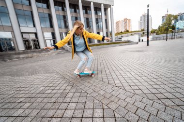 Sarışın, hippi bir kadın şehrin sokaklarında sörf tahtasında.