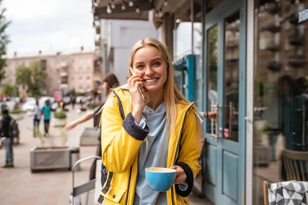 Очаровательная блондинка со смартфоном на улице — стоковое фото