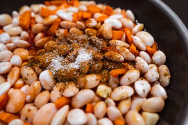 Pişirmeden önce havuç, sarımsak ve tuzlu fasulye ve baharatlı tava..