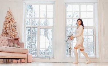 Kameraya poz veren beyaz elbiseli güzel bir genç kız. Noel konsepti