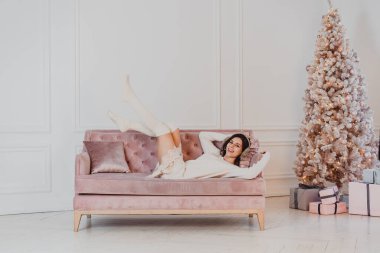 Güzel kadın kanepede yatıyor.