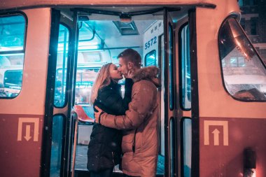 Kız ve erkek tramvayda öpüşürler.