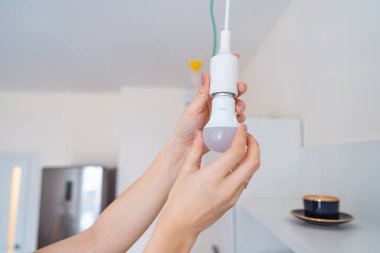 Kadın bir ampulü sökmez ışığa