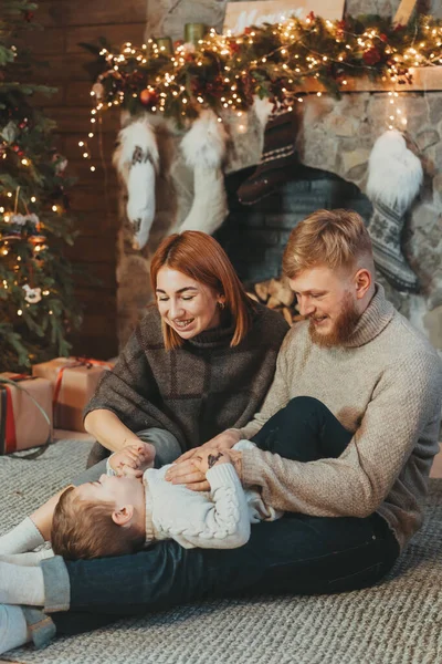 Молода біла родина мама тато син біля каміну Різдвяна ялинка — стокове фото