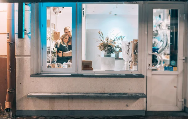 Foto melalui jendela. Pasangan muda di kafe dengan interior bergaya — Stok Foto