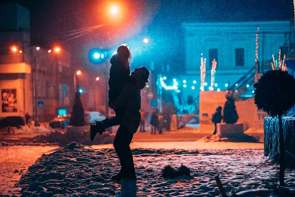 Unga vuxna par i varandra armar på snötäckta gatan. — Stockfoto