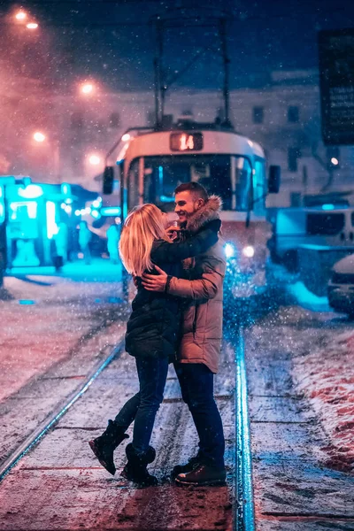 Couple de jeunes adultes sur la ligne de tramway enneigée — Photo