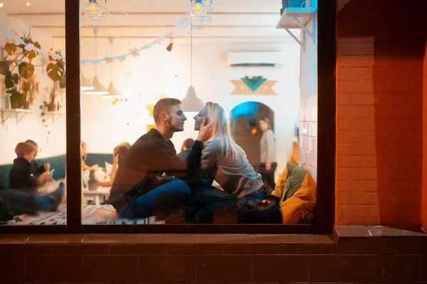 Фотографія через вікно. Молода пара в кафе зі стильним інтер'єром — стокове фото