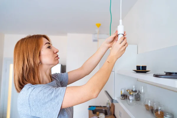 Femme dévisser une ampoule à la lumière ne s'allume pas — Photo