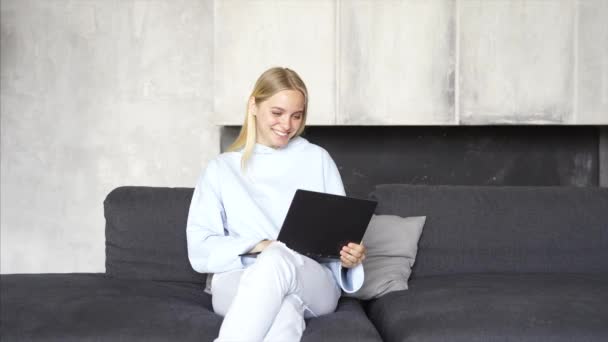 Las mujeres trabajan con ordenadores portátiles en el sofá de la habitación por la mañana . — Vídeos de Stock