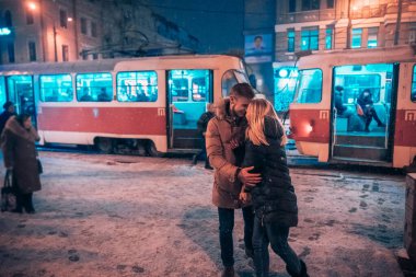 Karla kaplı tramvay istasyonunda genç bir çift