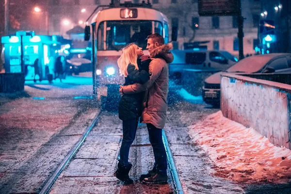 Unga vuxna par på den snötäckta spårvagnslinjen — Stockfoto