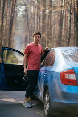 Yolda duran yakışıklı adam arabasının kapısını açtı..