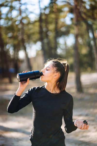 Mujer joven delgada bebiendo agua después del entrenamiento — Foto de Stock