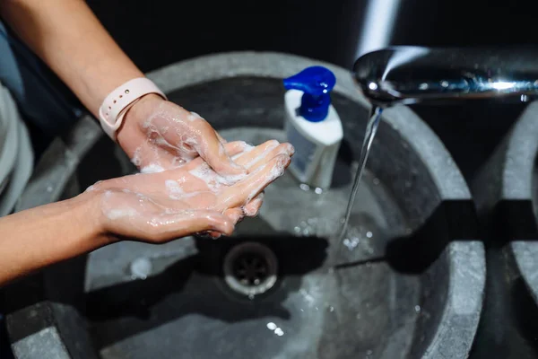 Kvinnan tvättar händerna för att skydda mot coronavirus — Stockfoto