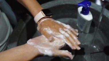 Koronavirüsten korunmak için ellerini yıkayan kadın.