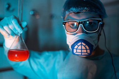 Genç erkek araştırmacı bilimsel deney yapıyor..