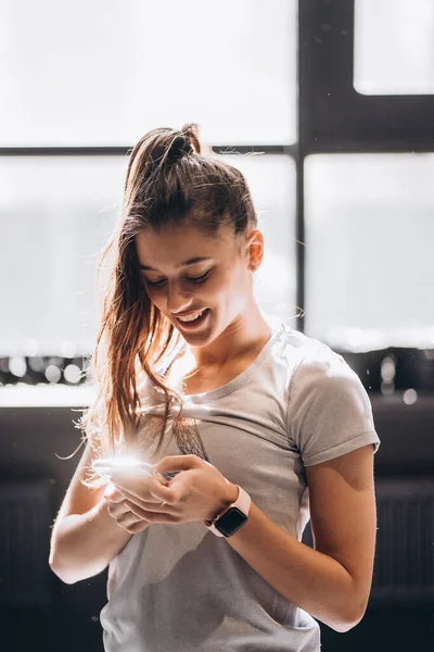 Happy girl membaca pesan di telepon pintar di rumah — Stok Foto