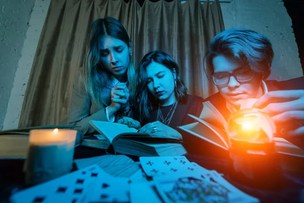 ２人の女性と１人の男が謎の本を読んでいる — ストック写真
