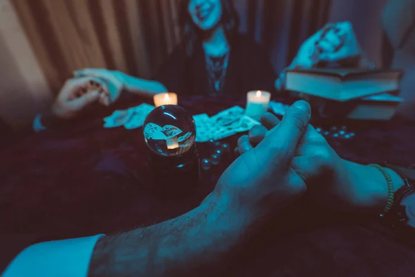 Ludzie trzymają się za ręce nocy przy stole ze świecami. — Zdjęcie stockowe