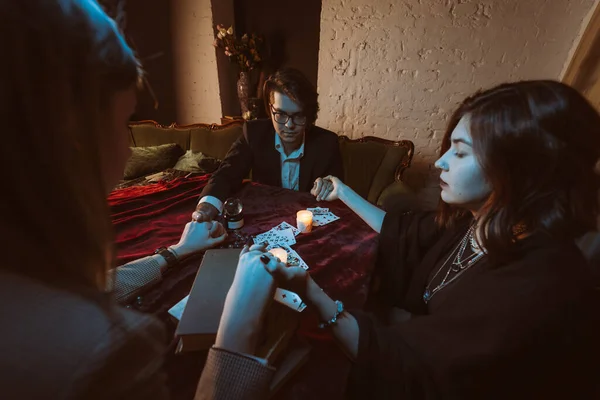 Mensen houden handen van de nacht aan tafel met kaarsen — Stockfoto
