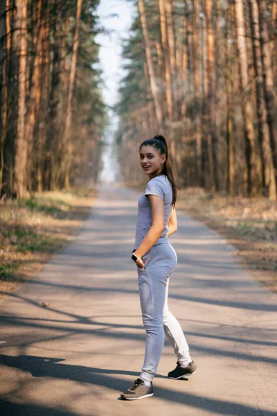 健康的年轻女子在公园里散步，摆出姿势面对镜头 — 图库照片