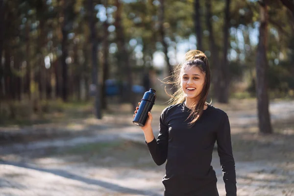 Mujer joven delgada bebiendo agua después del entrenamiento —  Fotos de Stock