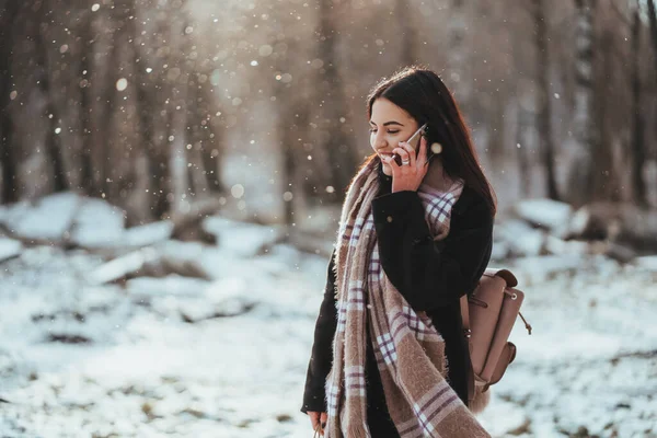 Mulher a falar ao telemóvel. Menina sorridente falando no telefone celular no dia frio de inverno . — Fotografia de Stock