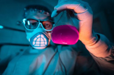 Genç erkek araştırmacı bilimsel deney yapıyor..