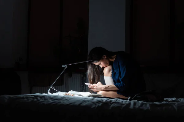 Zijaanzicht vrouw werken in donkere slaapkamer. — Stockfoto