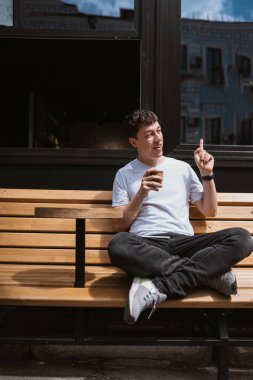 Caddedeki kafede esmer adam kahve içer..