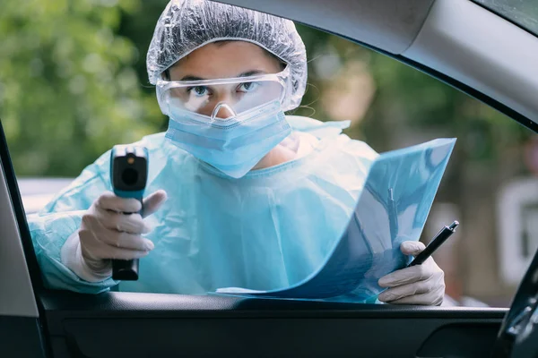 Läkare kvinna använder infraröd termometer pistol för att kontrollera kroppstemperaturen — Stockfoto