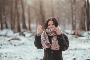 Genç ve güzel bir model kış ormanında poz veriyor. şık moda portresi