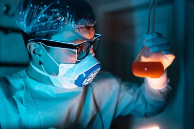 Genç erkek araştırmacı bilimsel deney yapıyor..