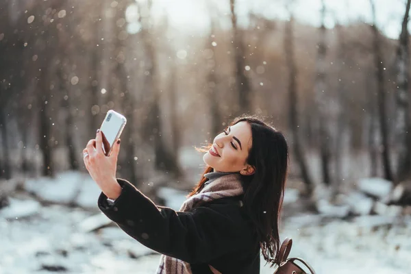 Glücklich lächelndes Teenager-Mädchen oder junge Frau beim Selfie mit dem Smartphone im Winterpark — Stockfoto