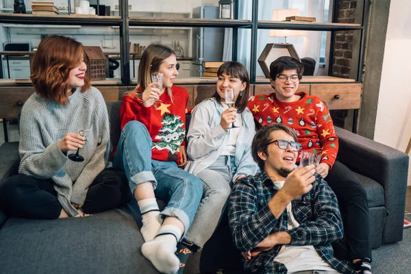 Grupo de amigos conversando sentado em um sofá na sala de estar — Fotografia de Stock