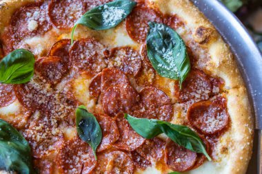 Sosisli ve fesleğenli pizza, yakın görüş.