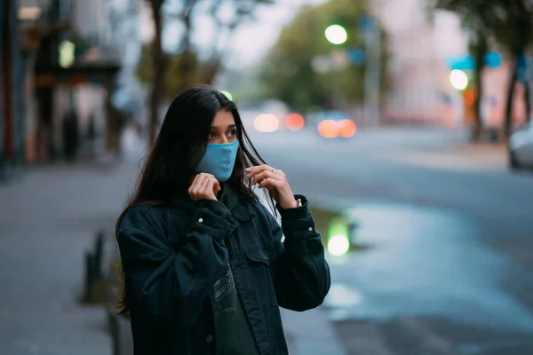Молодая женщина, человек в защитной стерильной маске на пустой улице — стоковое фото