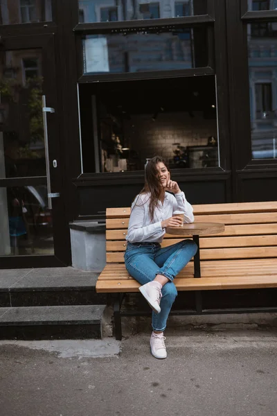 Красивая молодая женщина в уличном кафе пьет кофе — стоковое фото