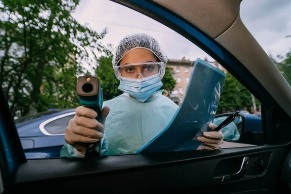 Läkare kvinna använder infraröd termometer pistol för att kontrollera kroppstemperaturen — Stockfoto