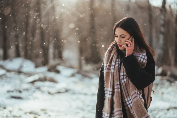 Kvinnan pratar i mobilen. Leende flicka talar på mobiltelefon i kall vinterdag. — Stockfoto