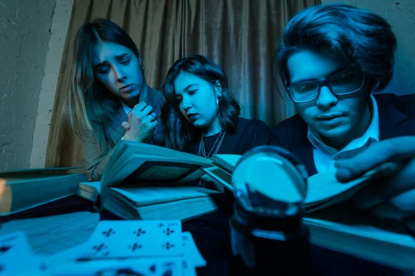Két nő és egy fickó egy titokzatos könyvet olvas, közelről. — Stock Fotó