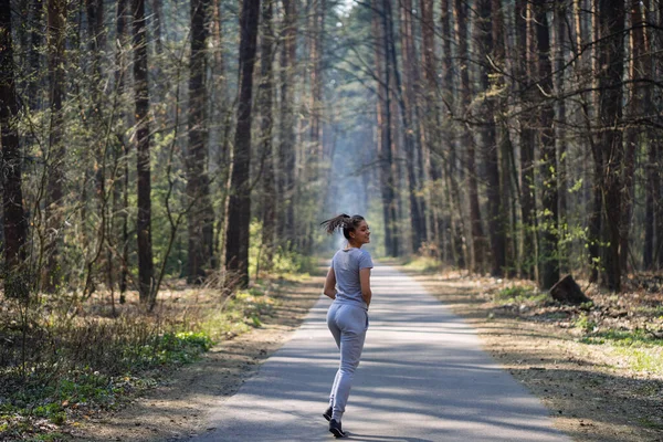 Gyönyörű fiatal nő fut a zöld parkban a napos nyári napon — Stock Fotó