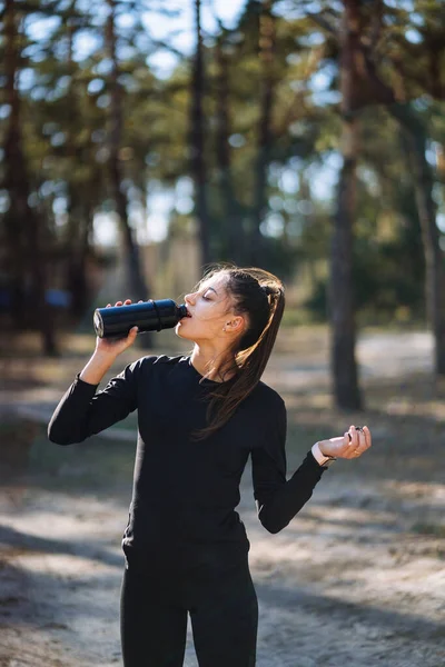 Mujer joven delgada bebiendo agua después del entrenamiento — Foto de Stock