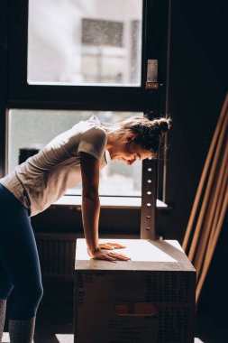 Güzel bir kadın pencereye yaslanmış masaya yaslanmış.