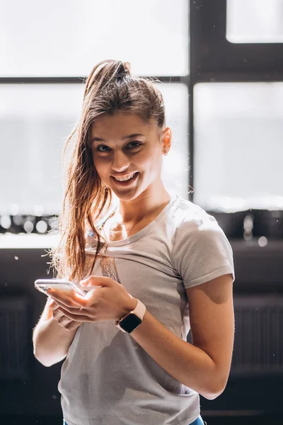 집에서 스마트폰으로 메시지를 읽고 있는 행복 한 소녀 — 스톡 사진