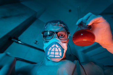 Genç erkek araştırmacı bilimsel deney yapıyor..