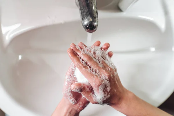 Człowiek myje ręce w celu ochrony przed koronawirusem — Zdjęcie stockowe